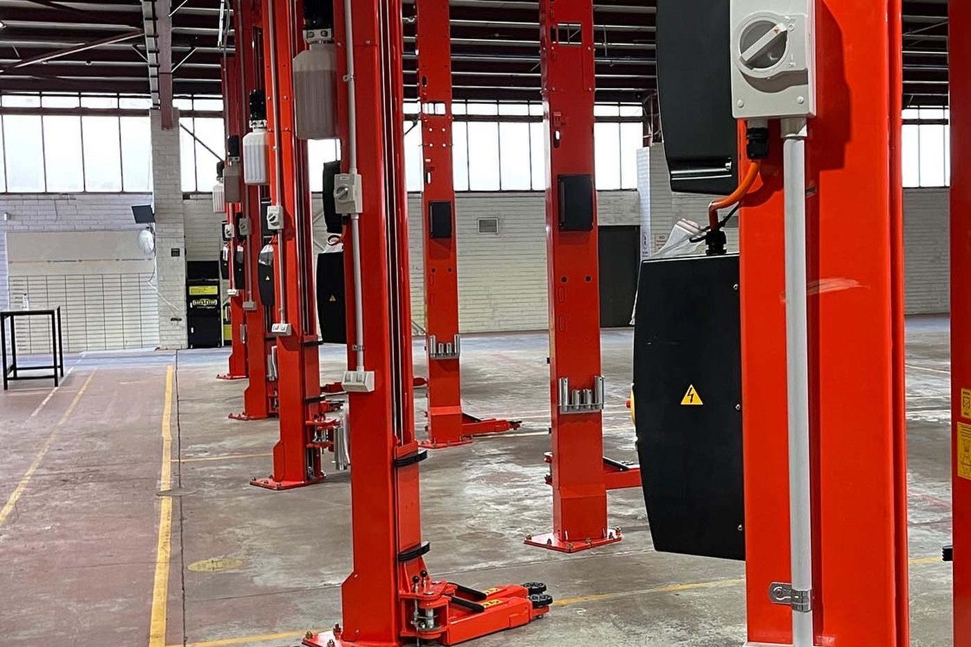 Two-post hoists in a mechanical workshop with power and isolation run to each one by SALTD Electrical