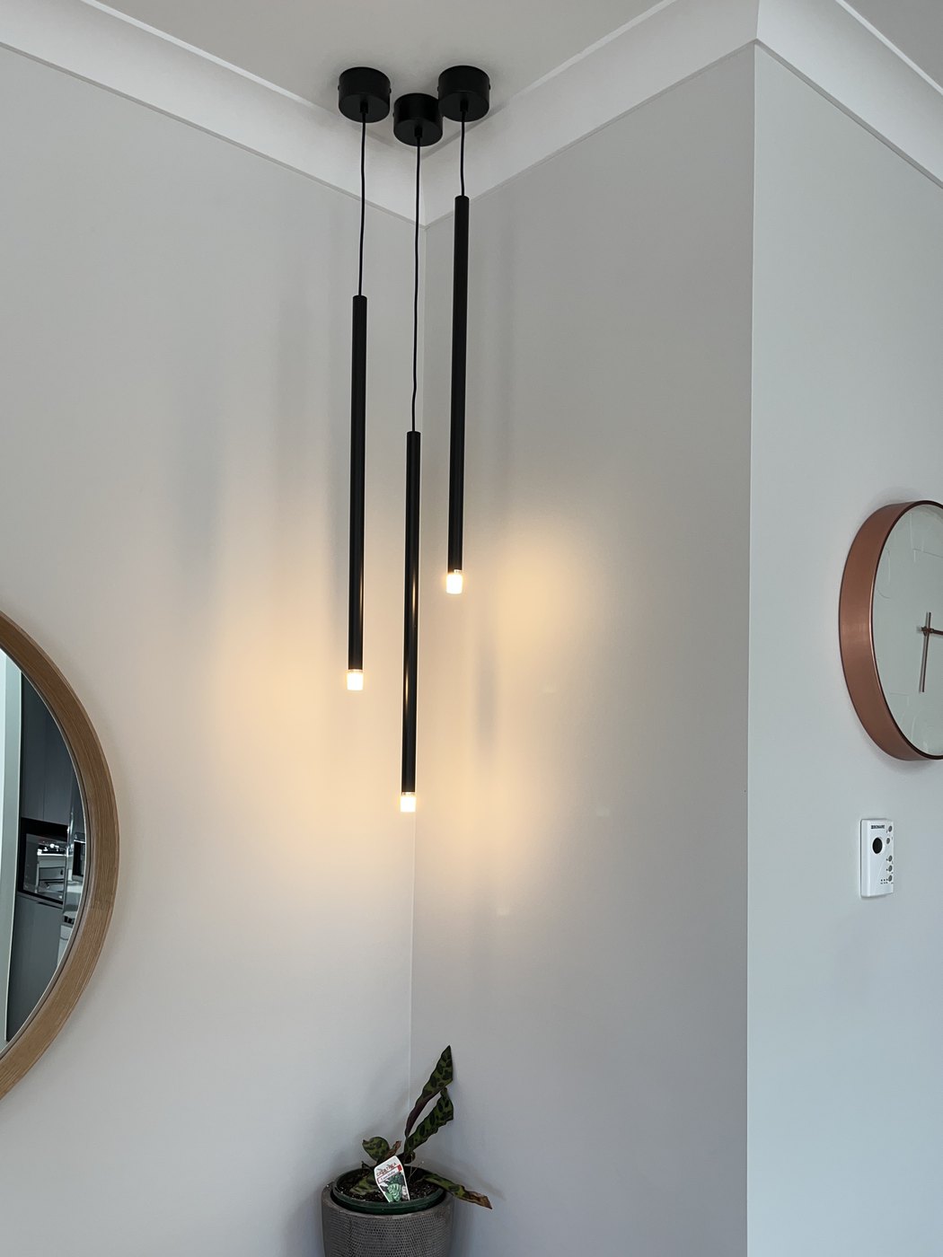 Three black cylinder pendant lights hung at staggered heights in the corner of a hallway, installed by SALTD Electrical