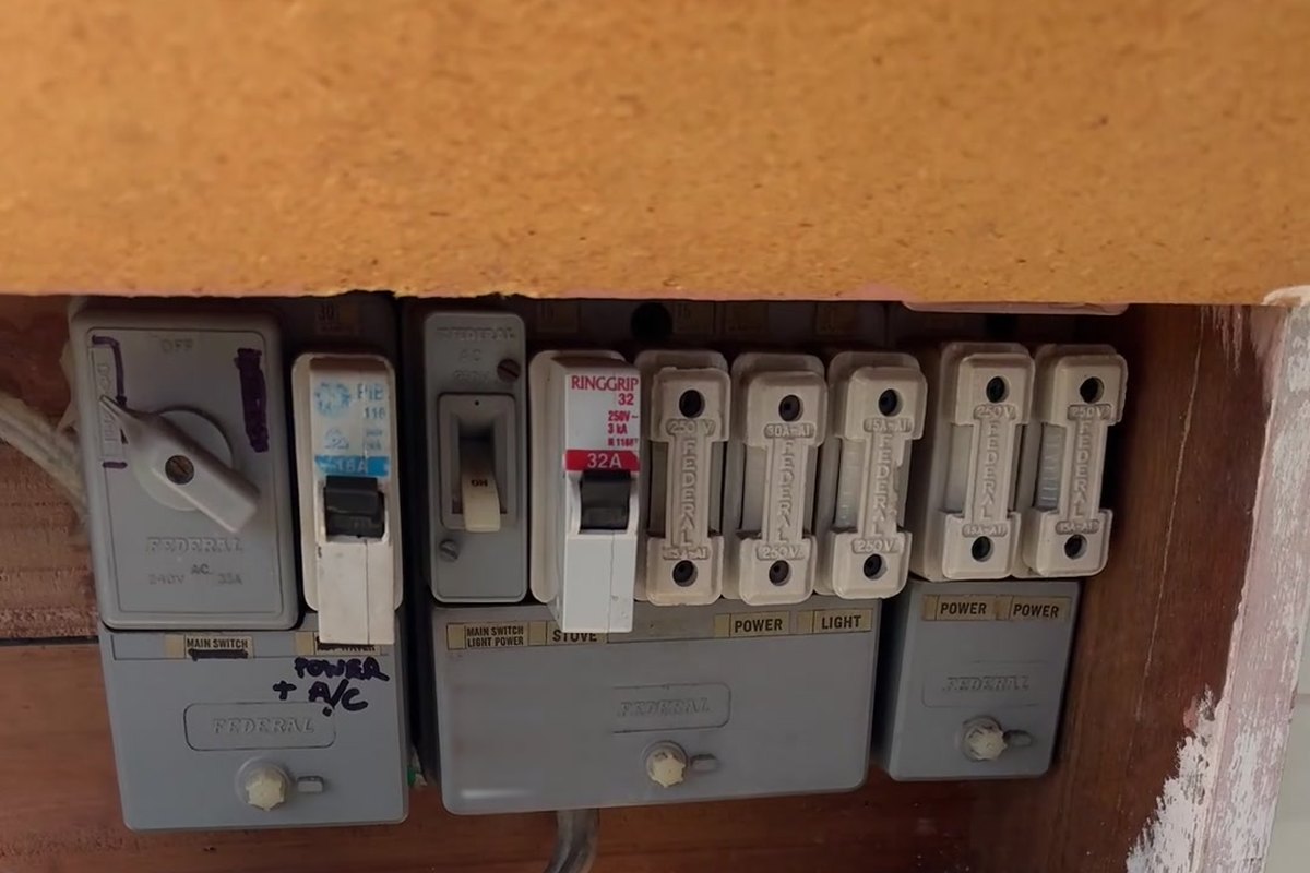 Old Federal switchboard with ceramic rewireable fuses and no safety switches, mounted in a timber recess, before upgrade by SALTD Electrical
